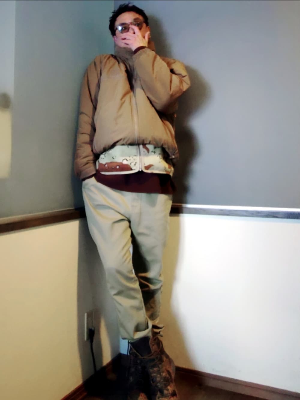 ブラウン系のベスト、ベージュ系のダウンジャケット/コート、グリーン系のパンツを着用したメンズの冬コーディネートの2枚目の写真