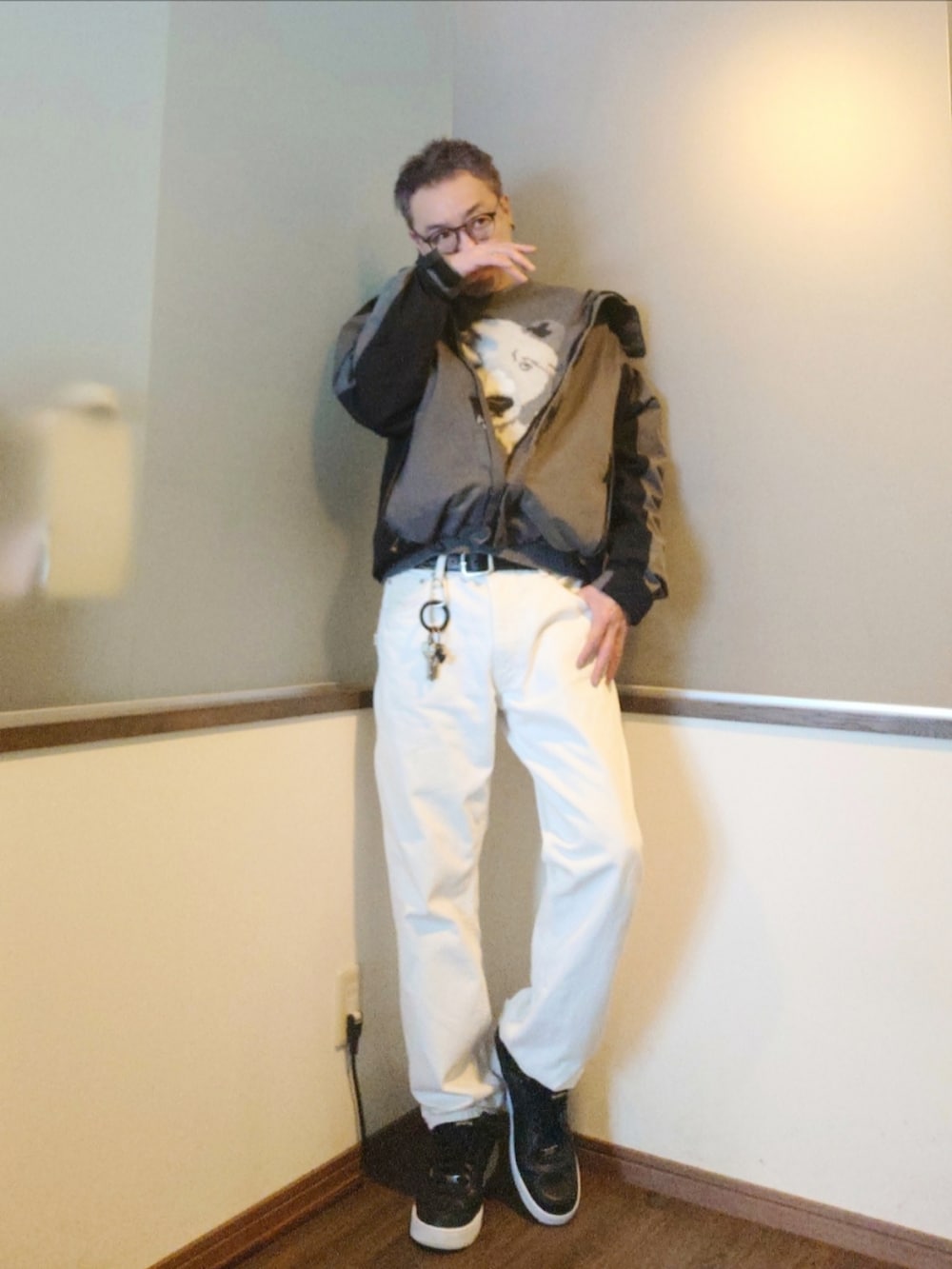 グレー系のマウンテンパーカー、グレー系のニット/セーター、ホワイト系のデニムパンツを着用したメンズの冬コーディネートの2枚目の写真