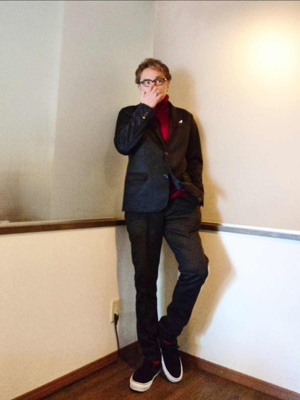 ブラック系のテーラードジャケット、レッド系のニット/セーター、ブラック系のスニーカーを着用したメンズの秋コーディネートの2枚目の写真