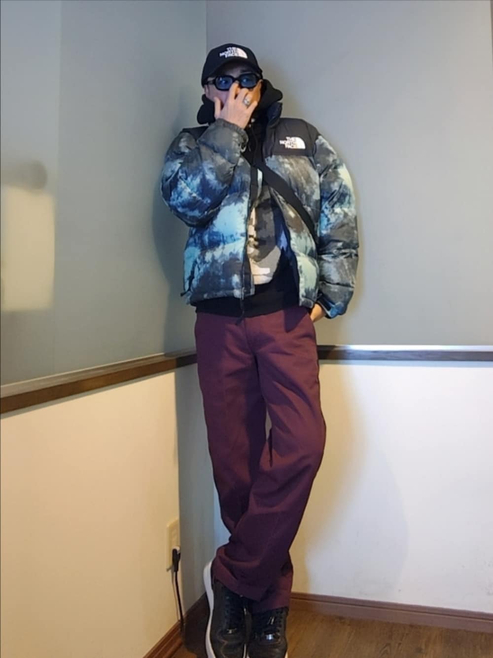 ブルー系のダウンジャケット/コート、ブラック系のニット/セーター、レッド系のチノパンツを着用したメンズの冬コーディネートの4枚目の写真