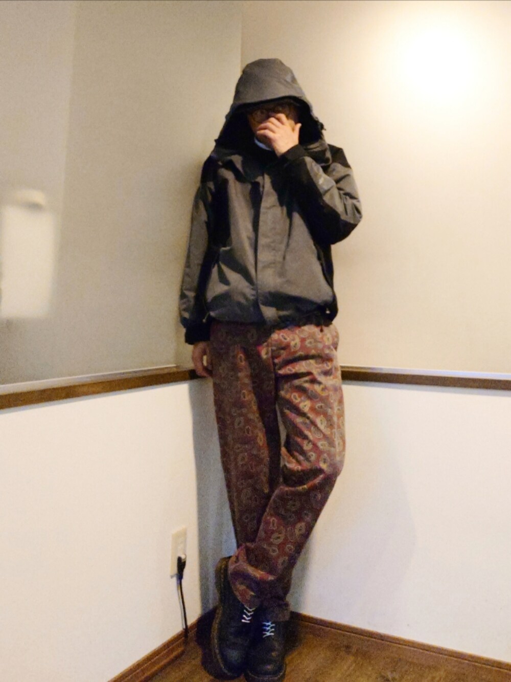 グレー系のマウンテンパーカー、ブルー系のニット/セーター、レッド系のチノパンツを着用したメンズの秋コーディネートの3枚目の写真