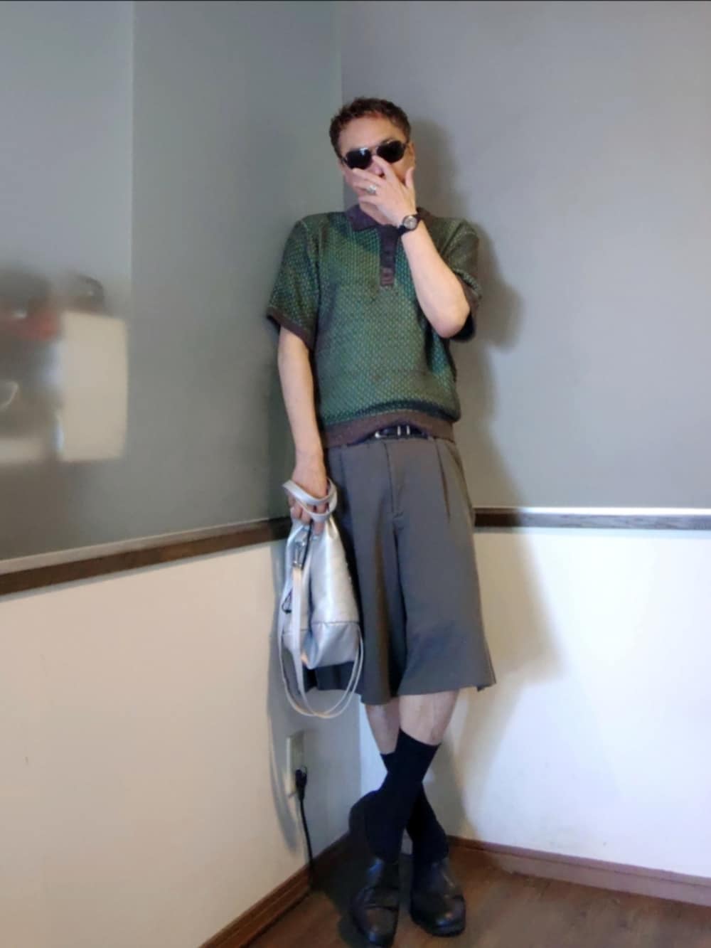 グリーン系のポロシャツ、グレー系のその他パンツ、ブラック系のスリッポンを着用したメンズの夏コーディネートの2枚目の写真