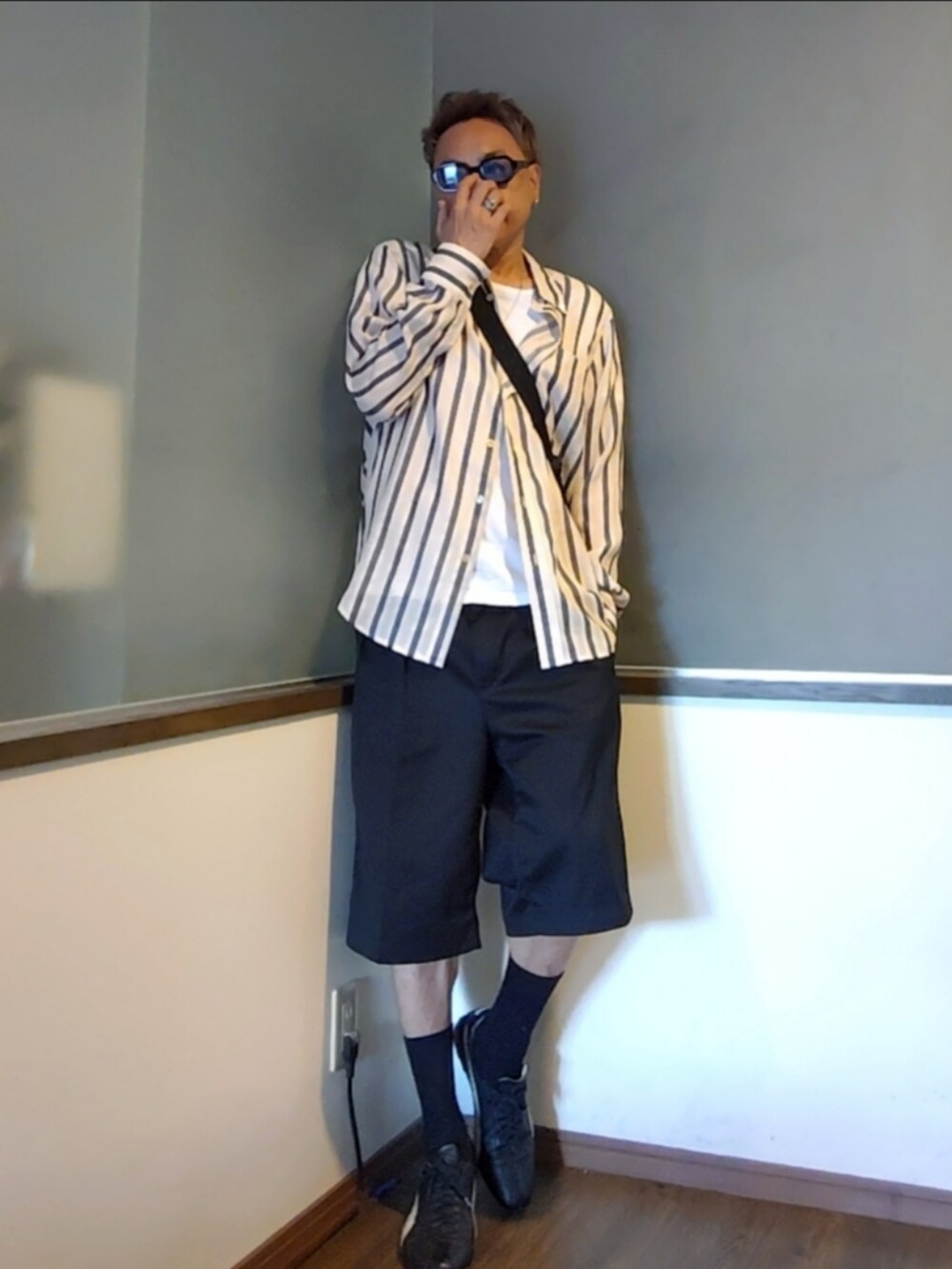 ホワイト系のシャツ/ブラウス、ブラック系のショルダーバッグ、ブラック系のチノパンツを着用したメンズの夏コーディネートの2枚目の写真