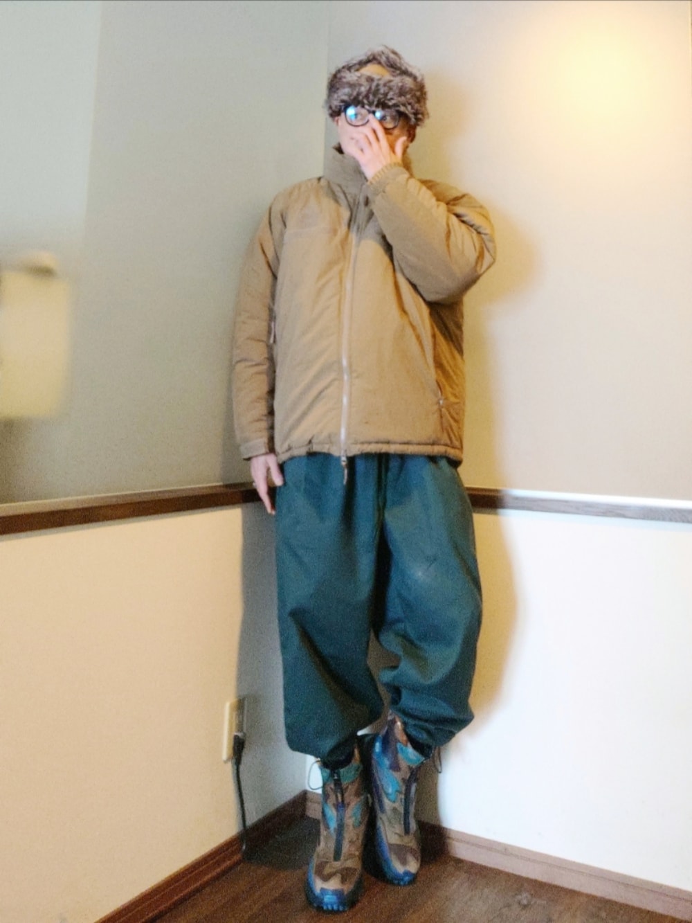 ベージュ系のダウンジャケット/コート、グリーン系のブルゾン、グリーン系のパンツを着用したメンズの秋コーディネートの4枚目の写真