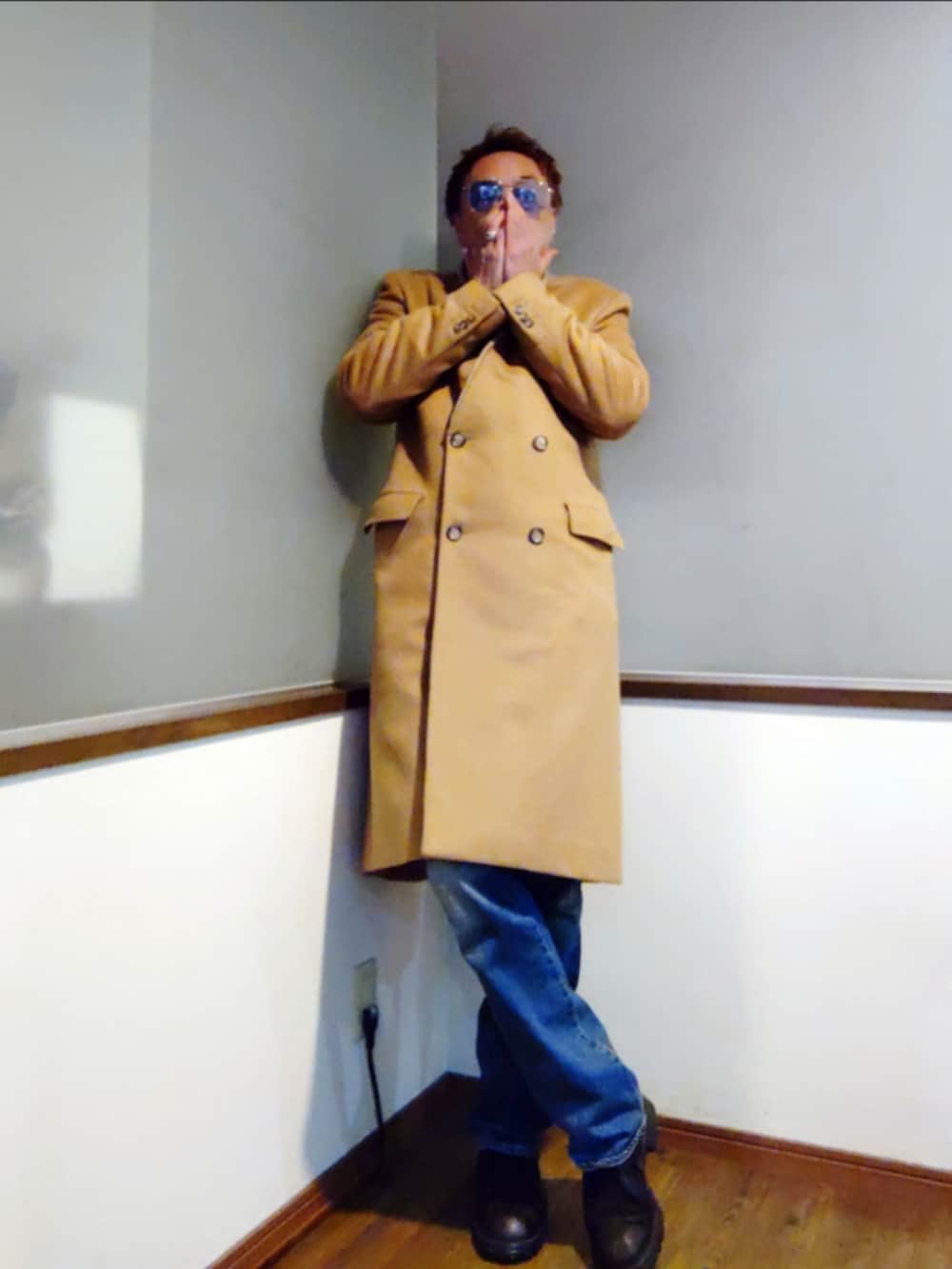 ブルー系のカバーオール、ブラック系のニット/セーター、ベージュ系のチェスターコートを着用したメンズの冬コーディネートの3枚目の写真