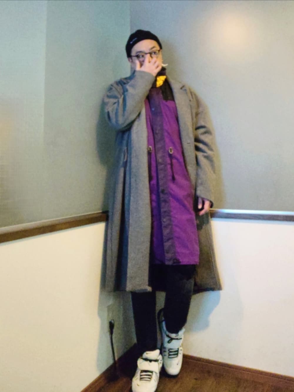 グレー系のチェスターコート、ホワイト系のスニーカー、ホワイト系のスニーカーを着用したメンズの冬コーディネートの2枚目の写真