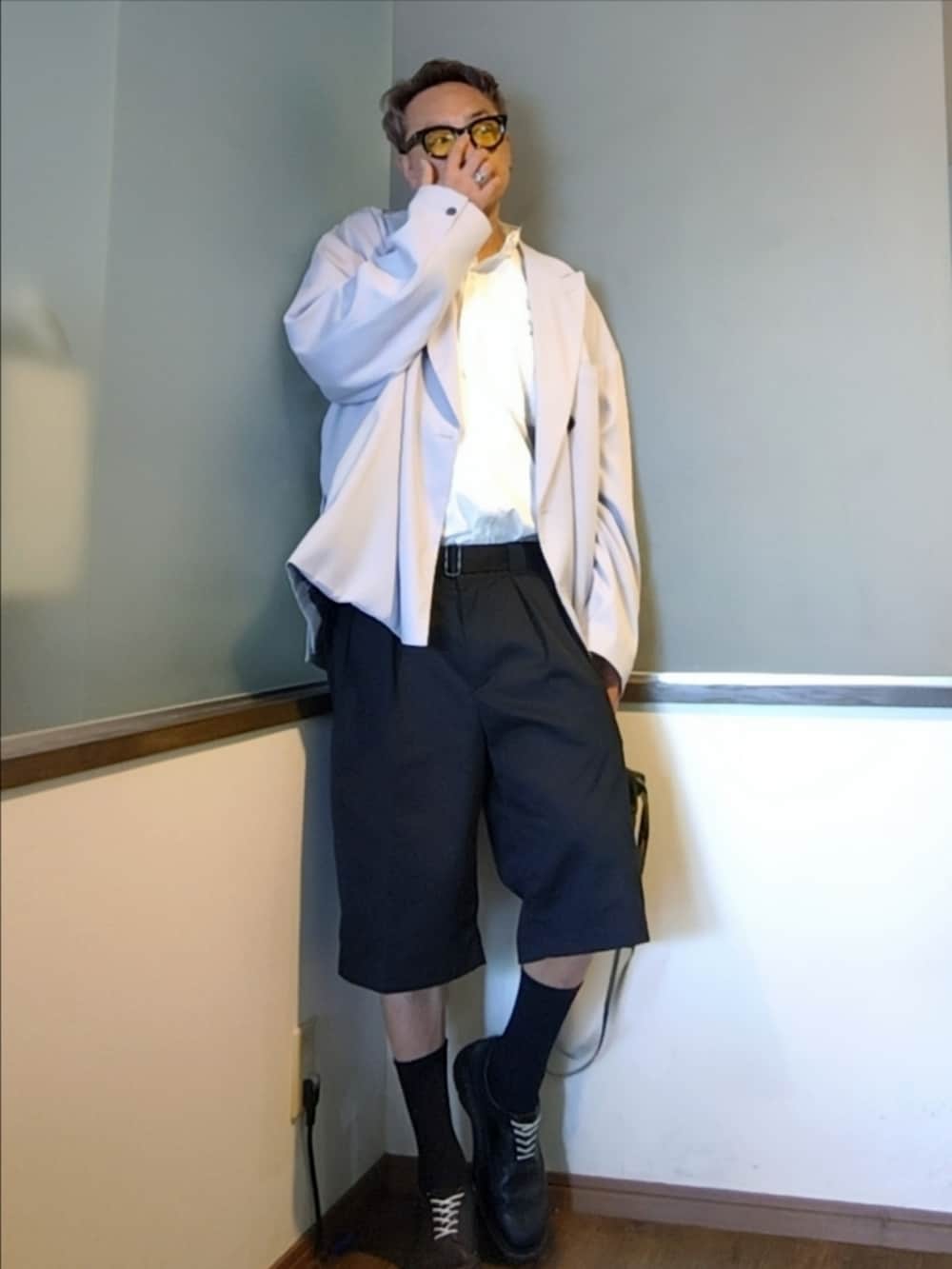 パープル系のテーラードジャケット、グリーン系のショルダーバッグ、ブラック系のチノパンツを着用したメンズの夏コーディネートの2枚目の写真