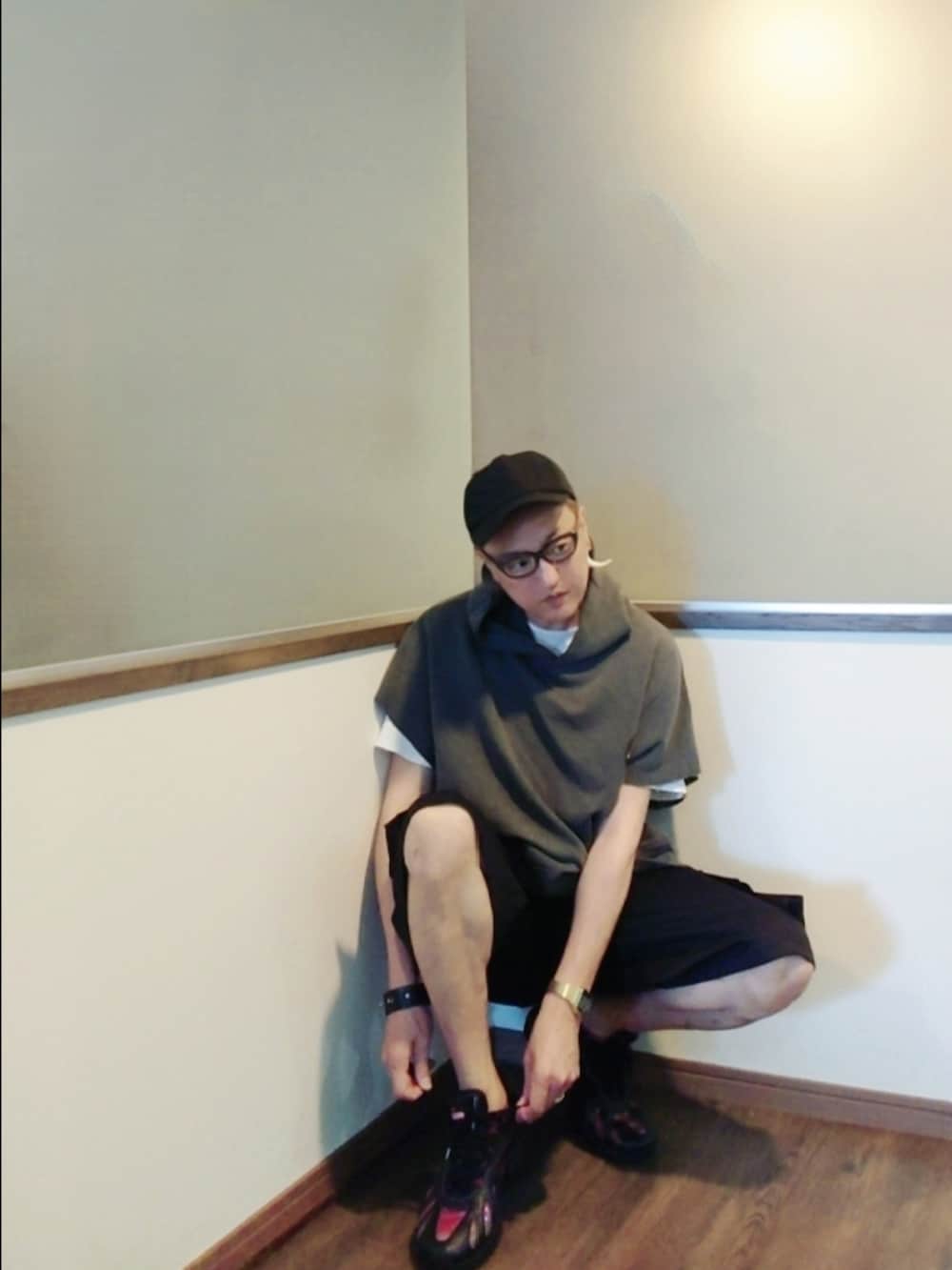 グレー系のパーカー、ブラック系のカーゴパンツ、ブラック系のスニーカーを着用したメンズの夏コーディネートの2枚目の写真