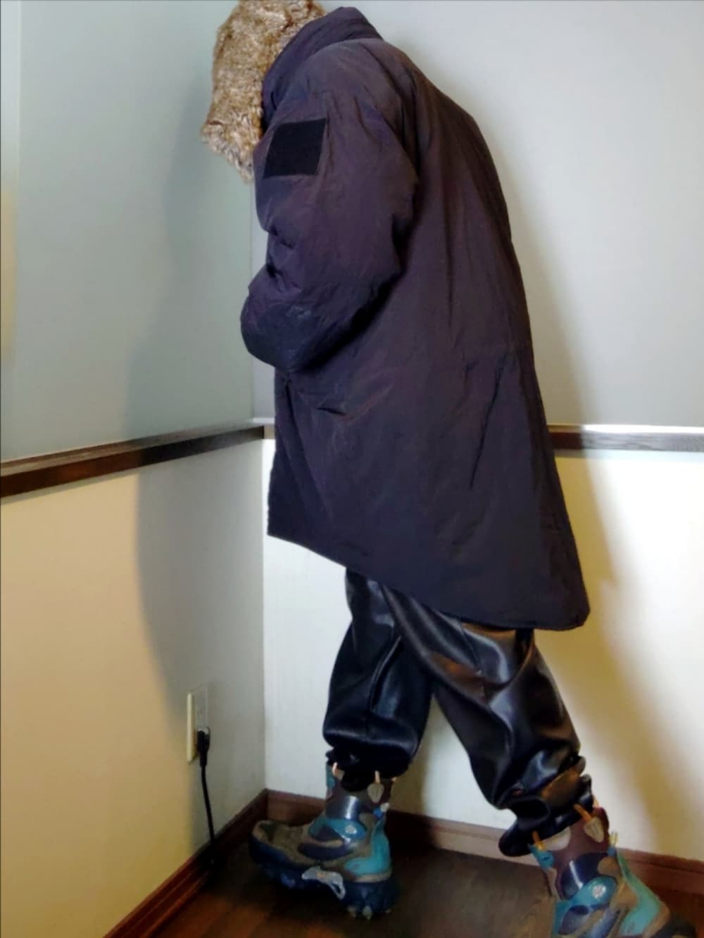 ブラック系のダウンジャケット/コート、ブルー系のデニムジャケット、グレー系のニット/セーターを着用したメンズの冬コーディネートの4枚目の写真