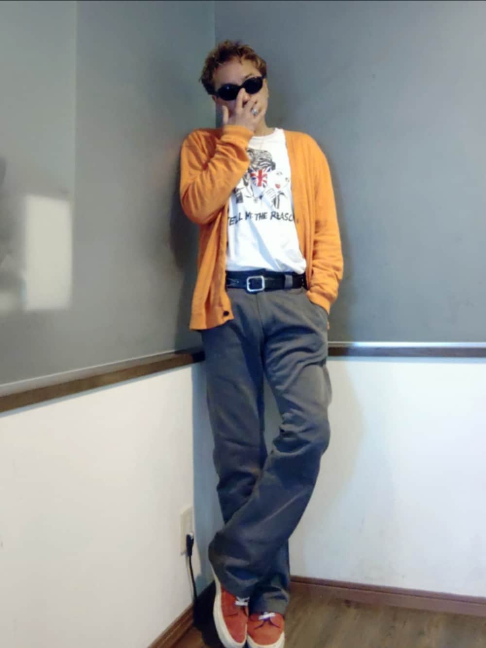 オレンジ系のカーディガン/ボレロ、ホワイト系のTシャツ/カットソー、グレー系のチノパンツを着用したメンズの秋コーディネートの3枚目の写真