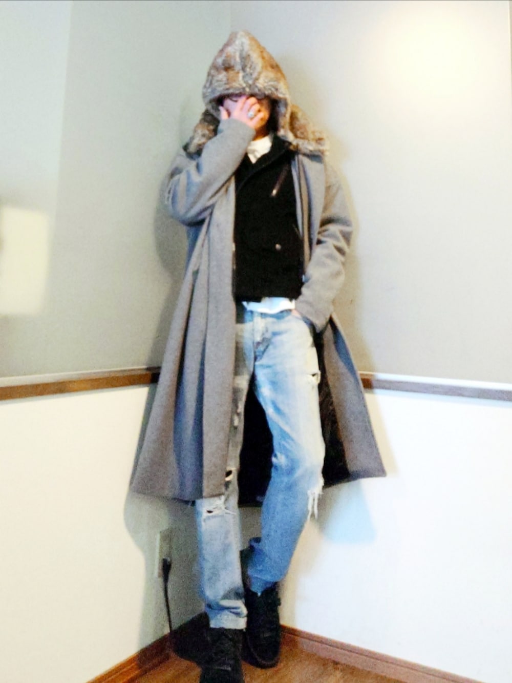 ブルー系のデニムパンツ、ブラック系のライダースジャケット、グレー系のチェスターコートを着用したメンズの冬コーディネートの2枚目の写真