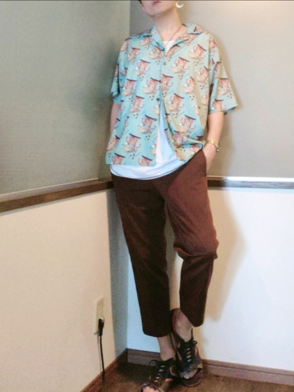 グリーン系のシャツ/ブラウス、ブラウン系のチノパンツ、パープル系のサンダルを着用したメンズの夏コーディネートの2枚目の写真