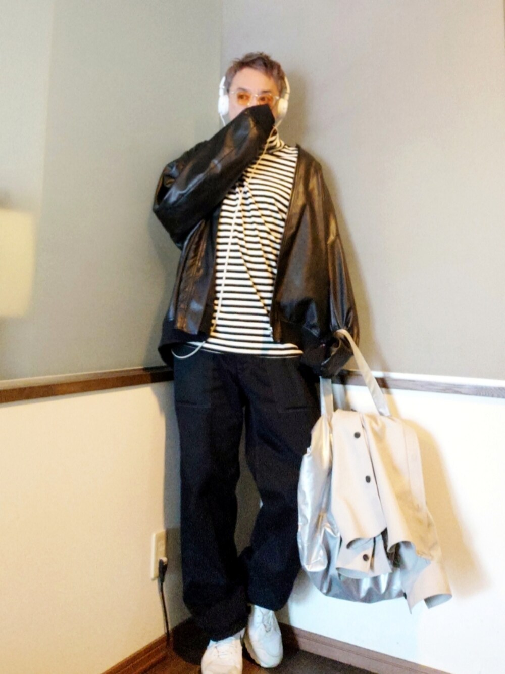 ブラック系のチノパンツ、ホワイト系のスニーカー、シルバー系のトートバッグを着用したメンズの春コーディネートの2枚目の写真