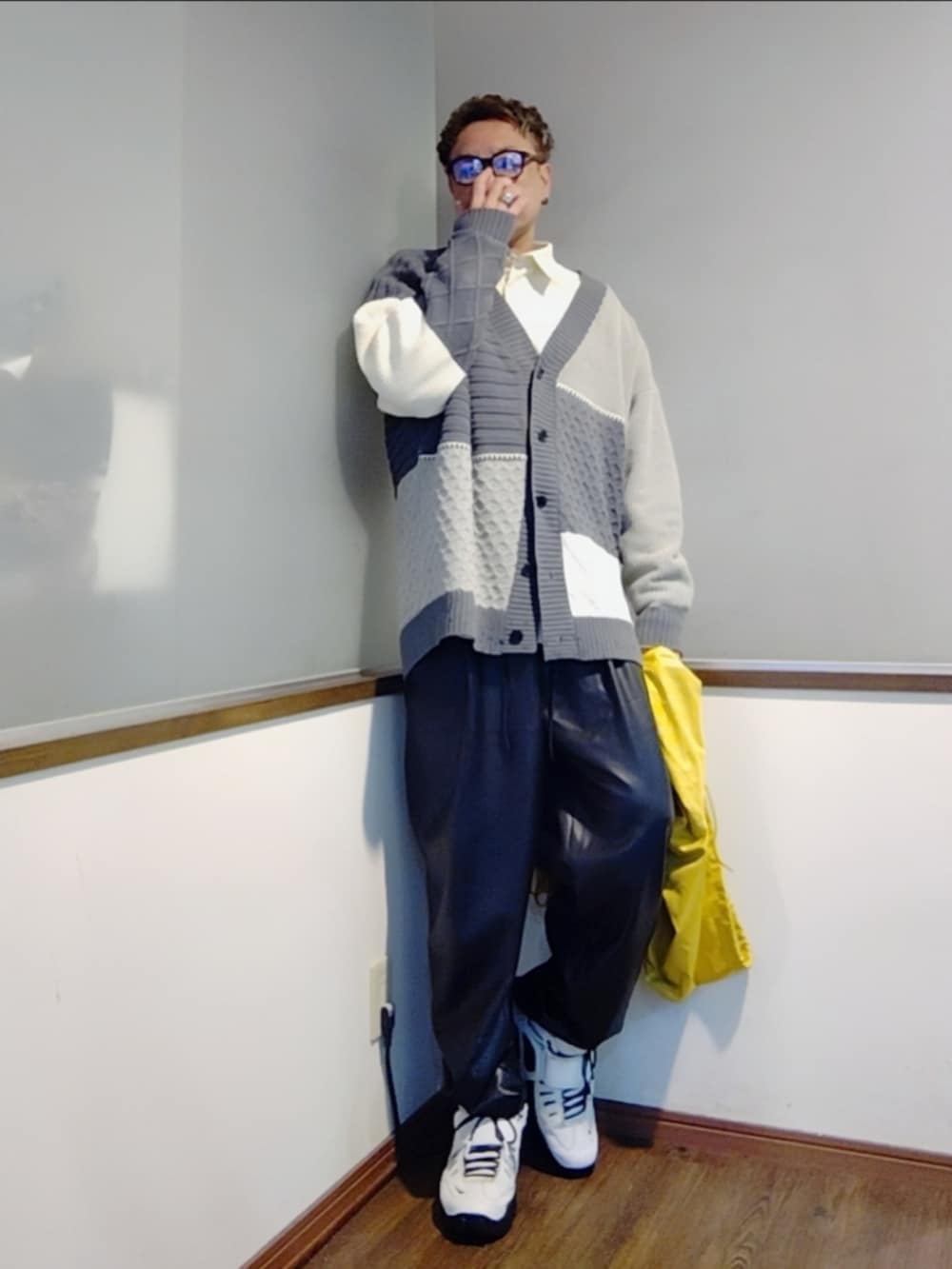 イエロー系のナイロンジャケット、グレー系のカーディガン/ボレロ、ホワイト系のシャツ/ブラウスを着用したメンズの秋コーディネートの2枚目の写真