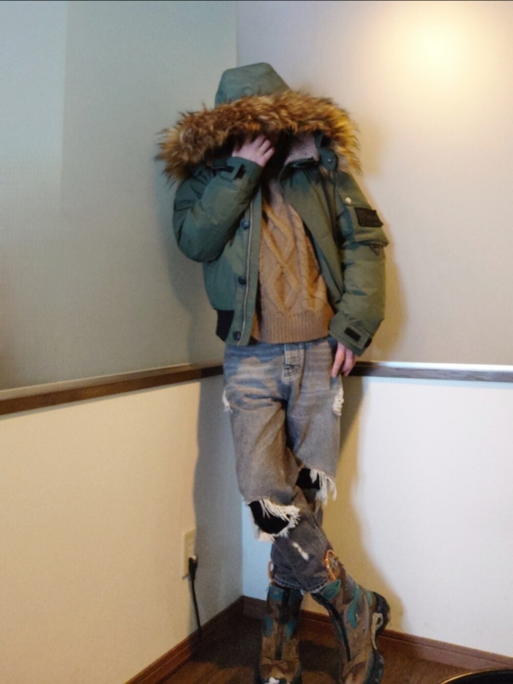 グリーン系のミリタリージャケット、ベージュ系のニット/セーター、グレー系のデニムパンツを着用したメンズの冬コーディネートの2枚目の写真