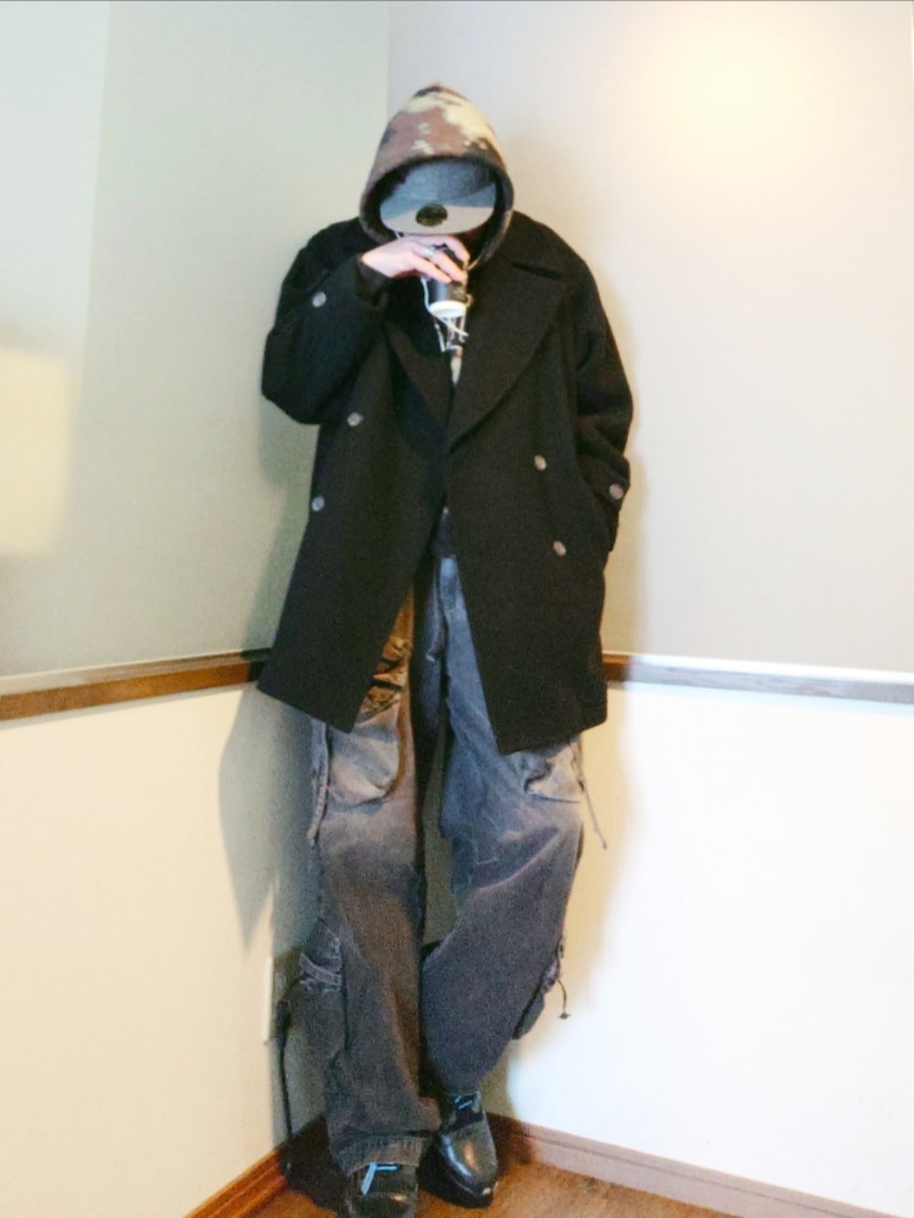 ブラック系のパーカー、ブラック系のピーコート、ブラック系のカーゴパンツを着用したメンズの冬コーディネートの2枚目の写真