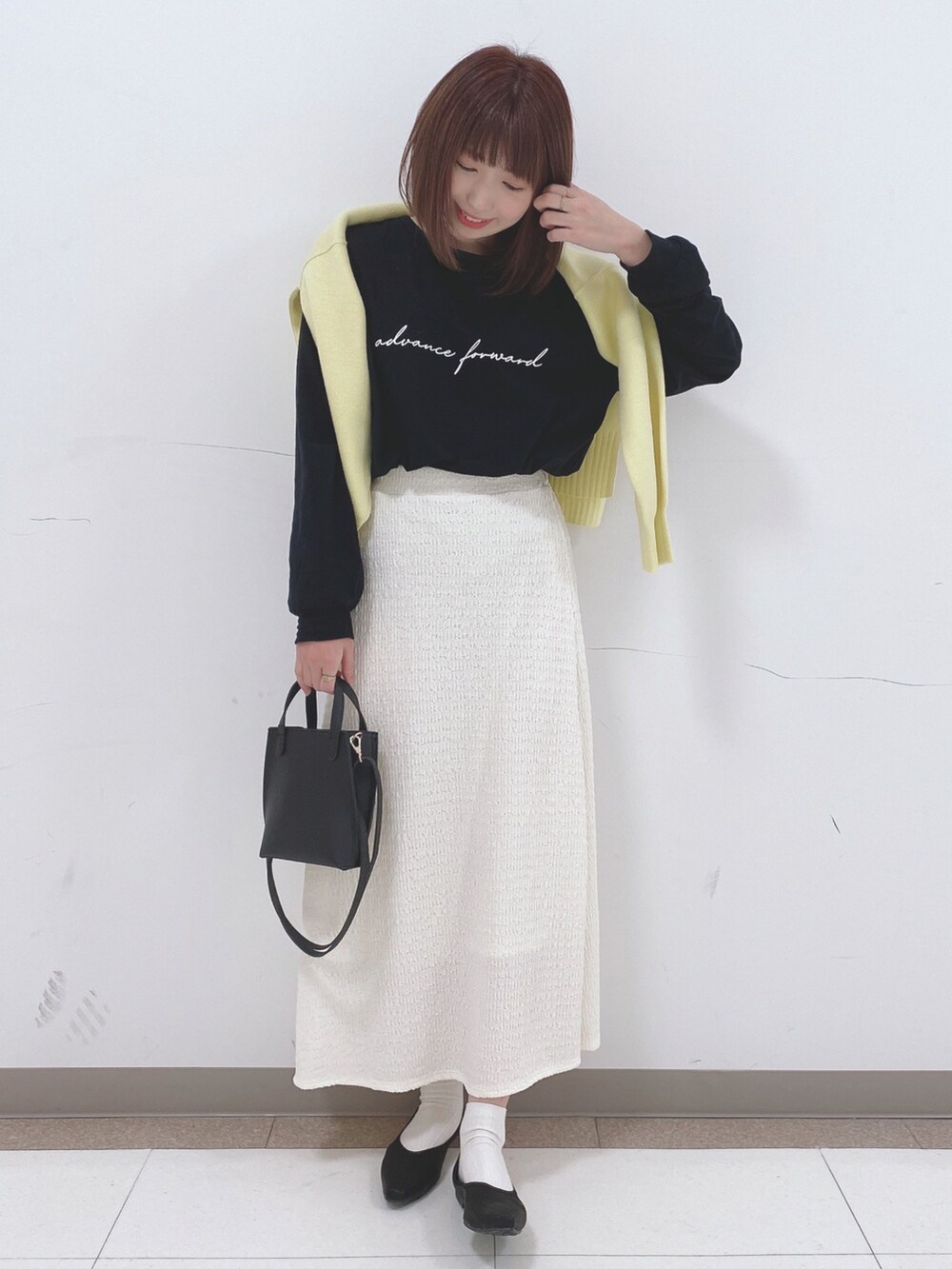 ブラック系のTシャツ/カットソー、イエロー系のニット/セーター、ブラック系のパンプスを着用したレディースの冬コーディネートの4枚目の写真