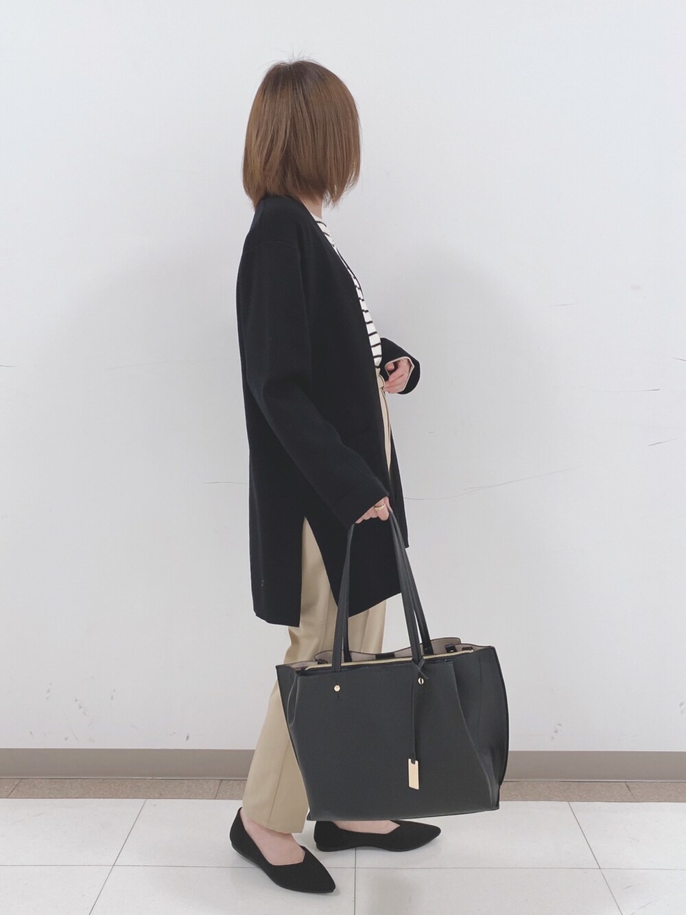 ホワイト系のニット/セーター、ベージュ系のその他パンツ、ブラック系のパンプスを着用したレディースの冬コーディネートの2枚目の写真