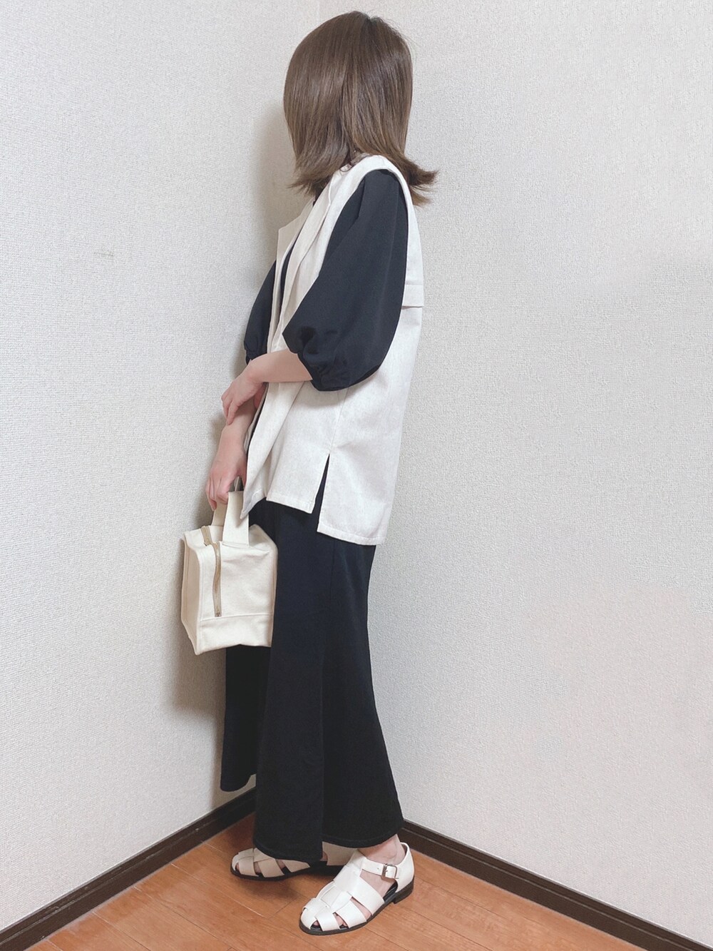 ブラック系のTシャツ/カットソー、ベージュ系のベスト、ブラック系のスカートを着用したレディースの春コーディネートの2枚目の写真