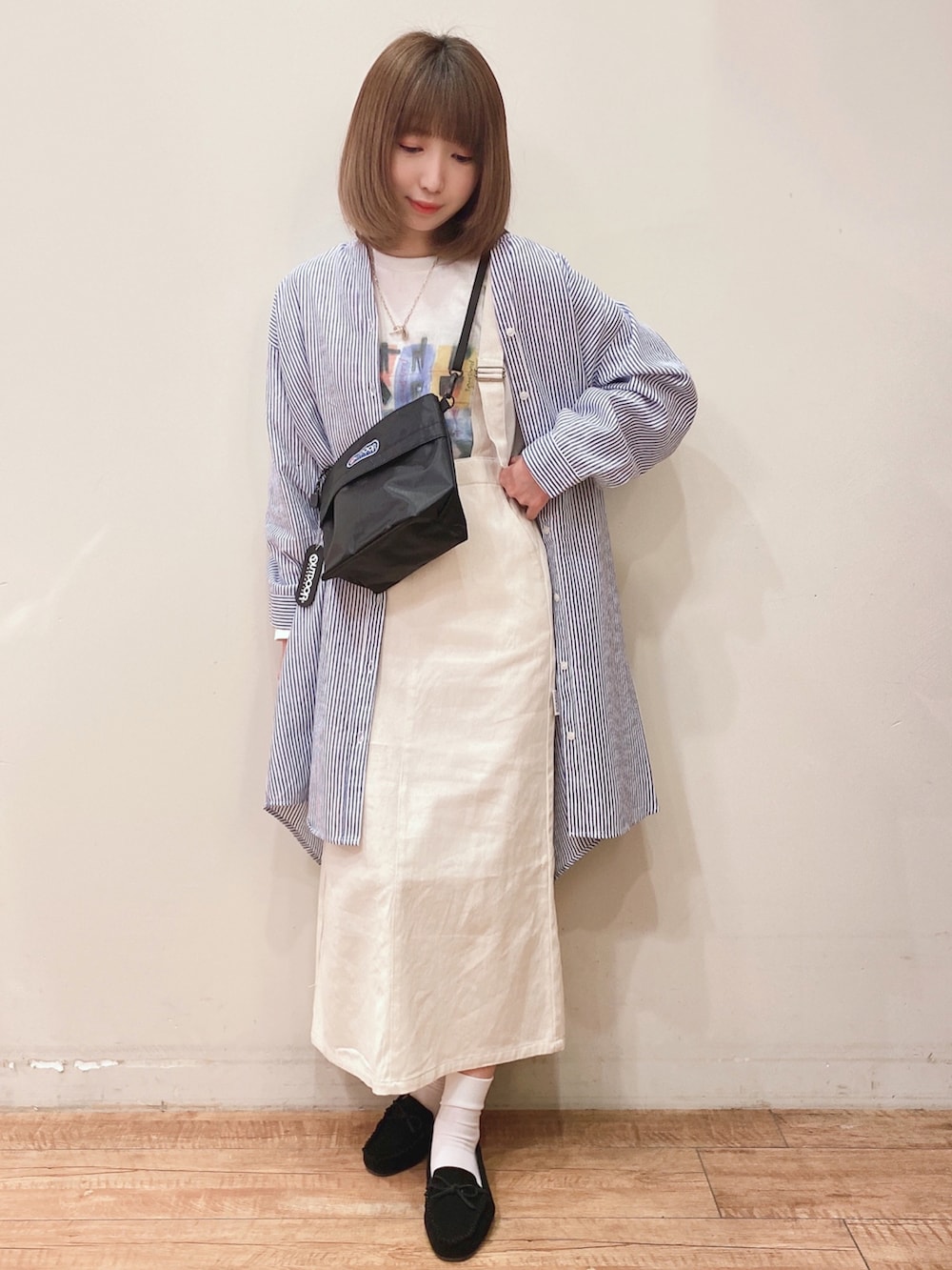 ホワイト系のスカート、ブラック系のショルダーバッグ、ブラック系のその他シューズを着用したレディースの春コーディネートの4枚目の写真