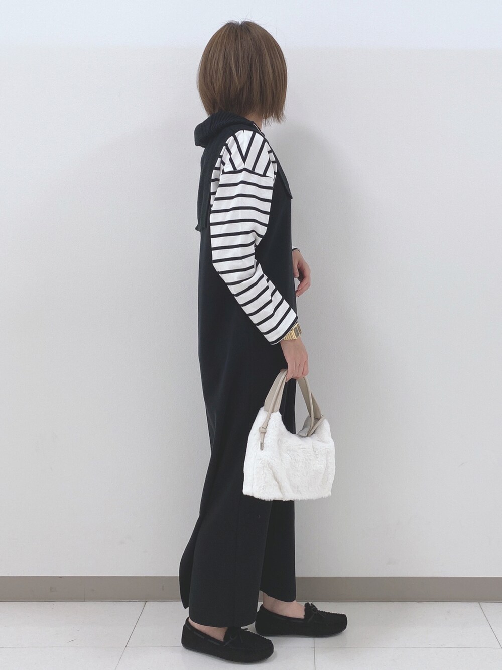 ブラック系のワンピース、ホワイト系のTシャツ/カットソー、ホワイト系のショルダーバッグを着用したレディースの秋コーディネートの2枚目の写真