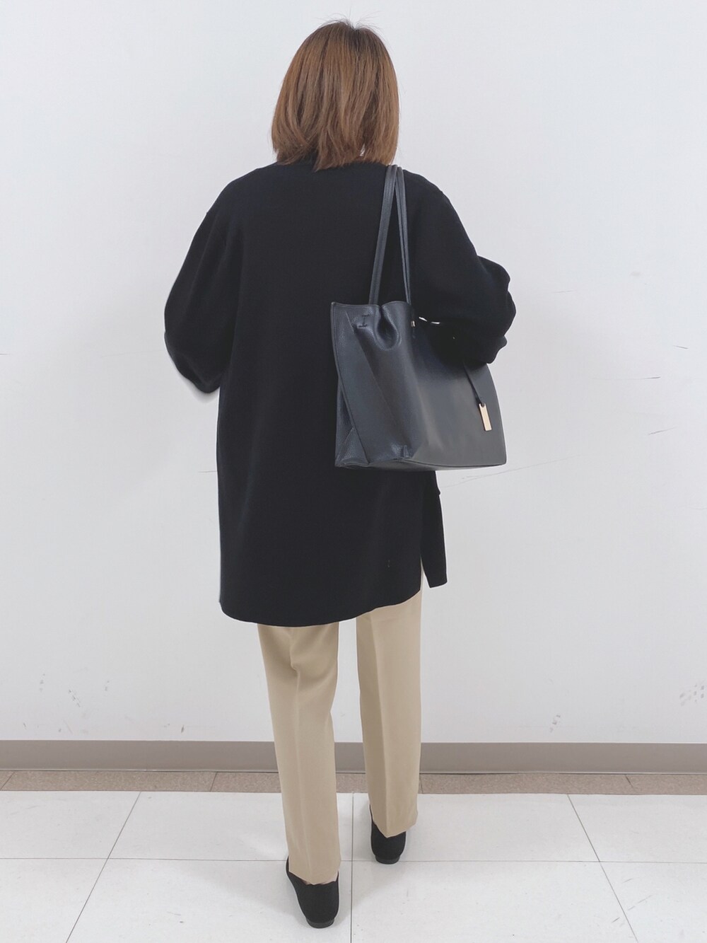 ホワイト系のニット/セーター、ベージュ系のその他パンツ、ブラック系のパンプスを着用したレディースの冬コーディネートの3枚目の写真