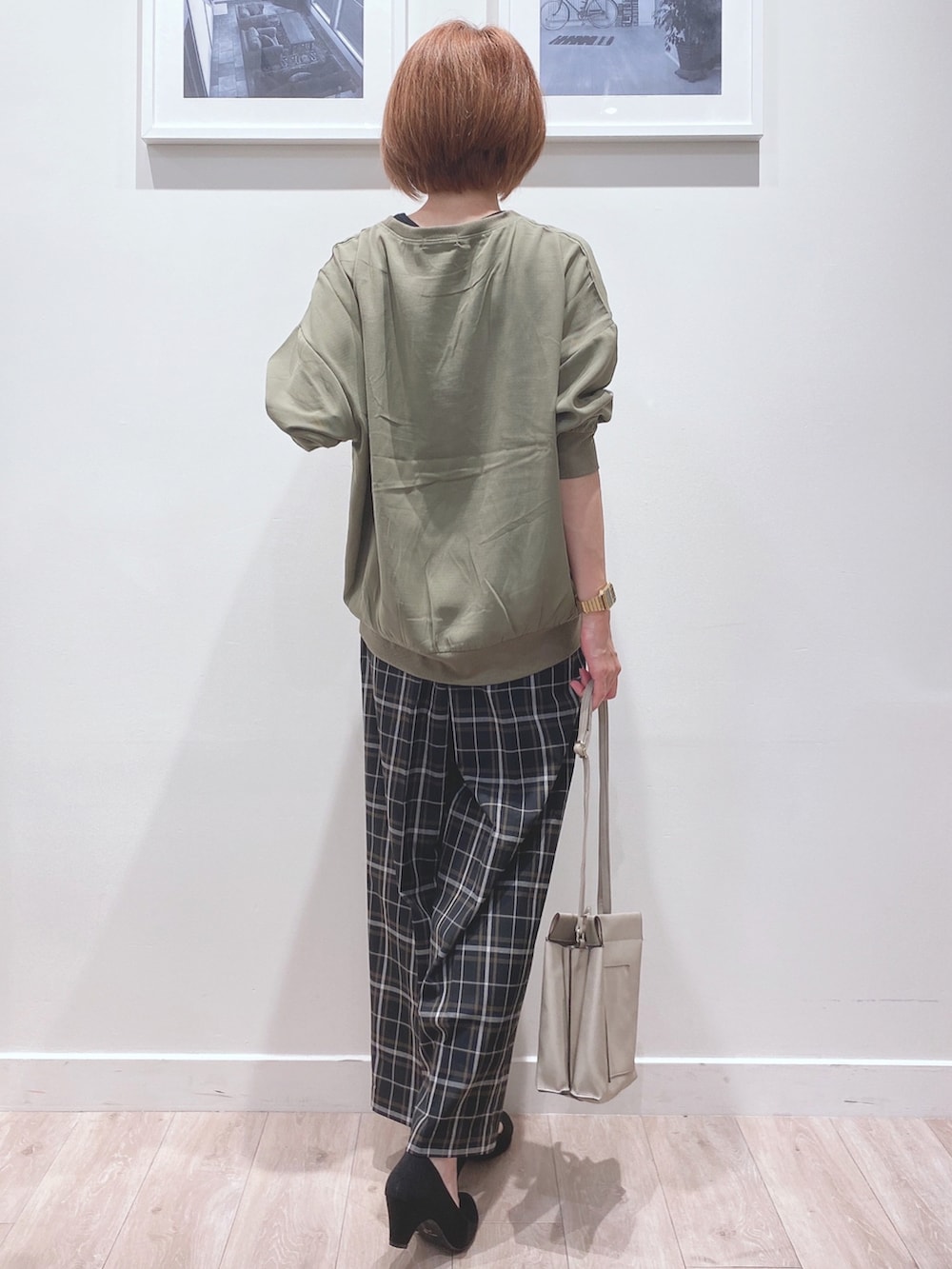 グリーン系のシャツ/ブラウス、ブラック系のパンツ、グレー系のショルダーバッグを着用したレディースの秋コーディネートの3枚目の写真