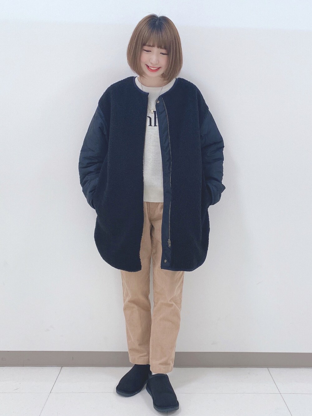 ブラック系のノーカラージャケット、ホワイト系のニット/セーター、イエロー系のその他パンツを着用したレディースの秋コーディネートの4枚目の写真