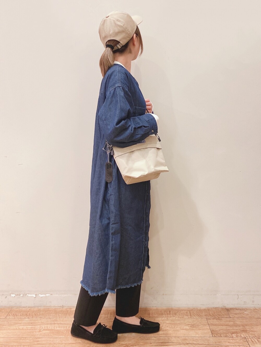ホワイト系のTシャツ/カットソー、ブルー系のワンピース、ベージュ系のショルダーバッグを着用したレディースの春コーディネートの2枚目の写真