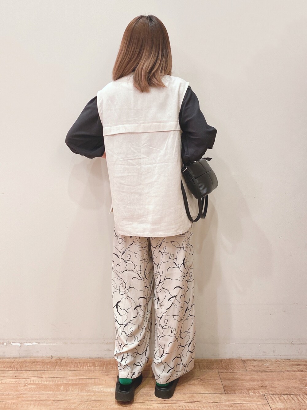 ベージュ系のベスト、ベージュ系のその他パンツ、ブラック系のショルダーバッグを着用したレディースの春コーディネートの3枚目の写真