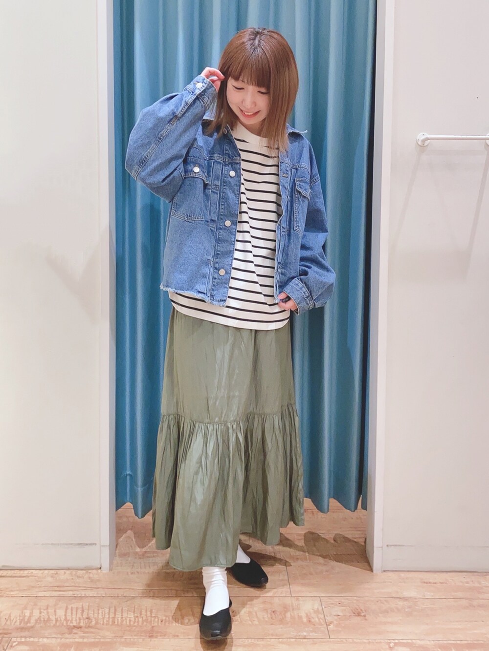 ブルー系のデニムジャケット、ブラック系のTシャツ/カットソー、グリーン系のスカートを着用したレディースの春コーディネートの4枚目の写真