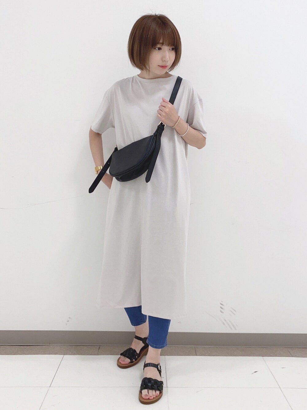 グレー系のワンピース、ブルー系のデニムパンツ、ブラック系のサンダルを着用したレディースの夏コーディネートの4枚目の写真