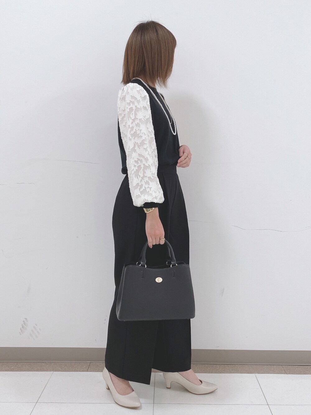 ブラック系のニット/セーター、ブラック系のその他パンツ、ベージュ系のパンプスを着用したレディースの冬コーディネートの2枚目の写真