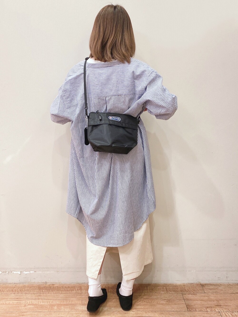 ホワイト系のスカート、ブラック系のショルダーバッグ、ブラック系のその他シューズを着用したレディースの春コーディネートの3枚目の写真