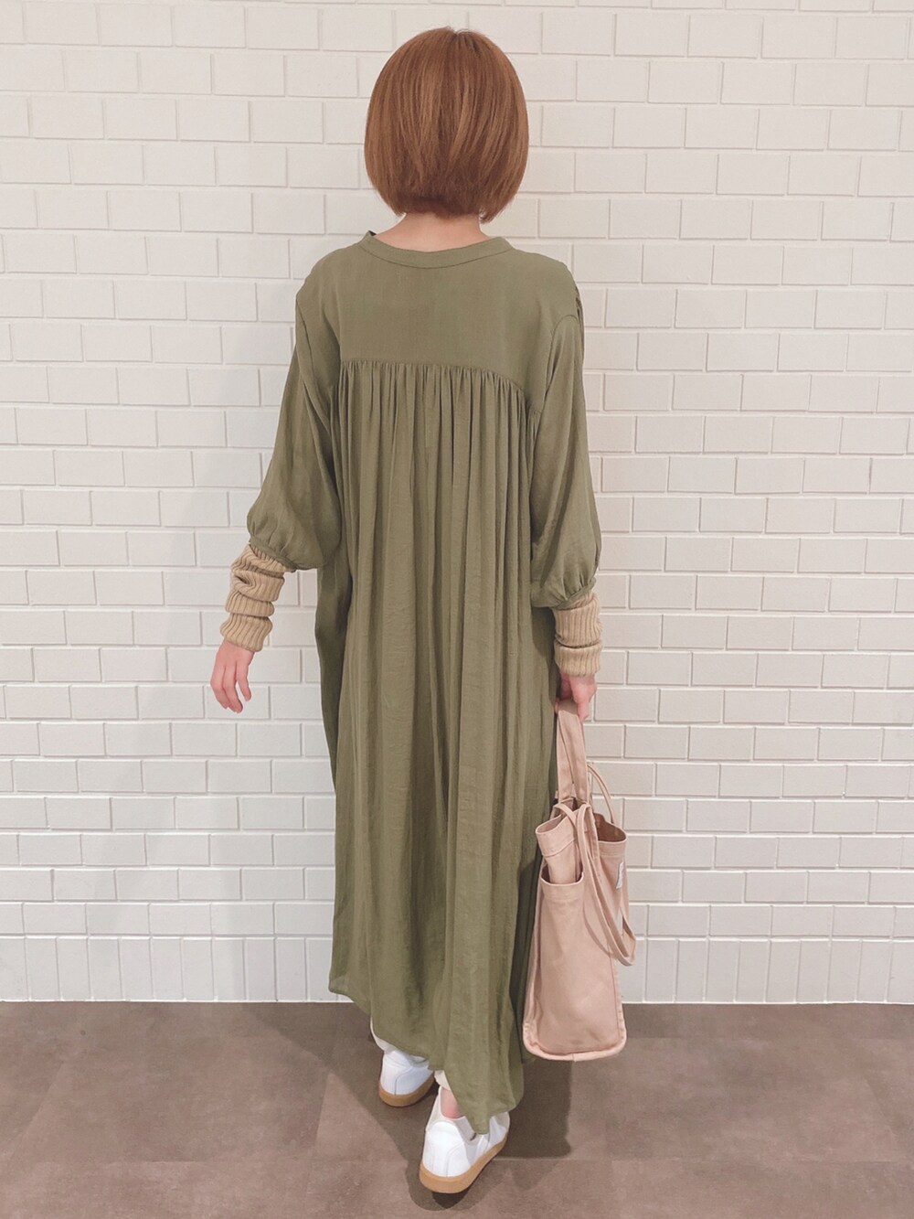 グリーン系のワンピース、ホワイト系のその他パンツ、ホワイト系のスニーカーを着用したレディースの秋コーディネートの2枚目の写真