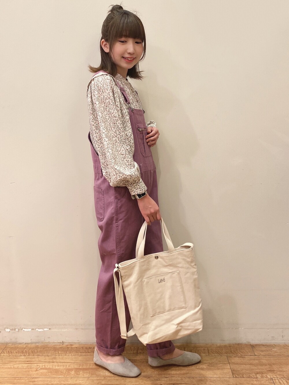 パープル系のサロペット/オーバーオール、ベージュ系のチュニック、ホワイト系のトートバッグを着用したレディースの春コーディネートの2枚目の写真