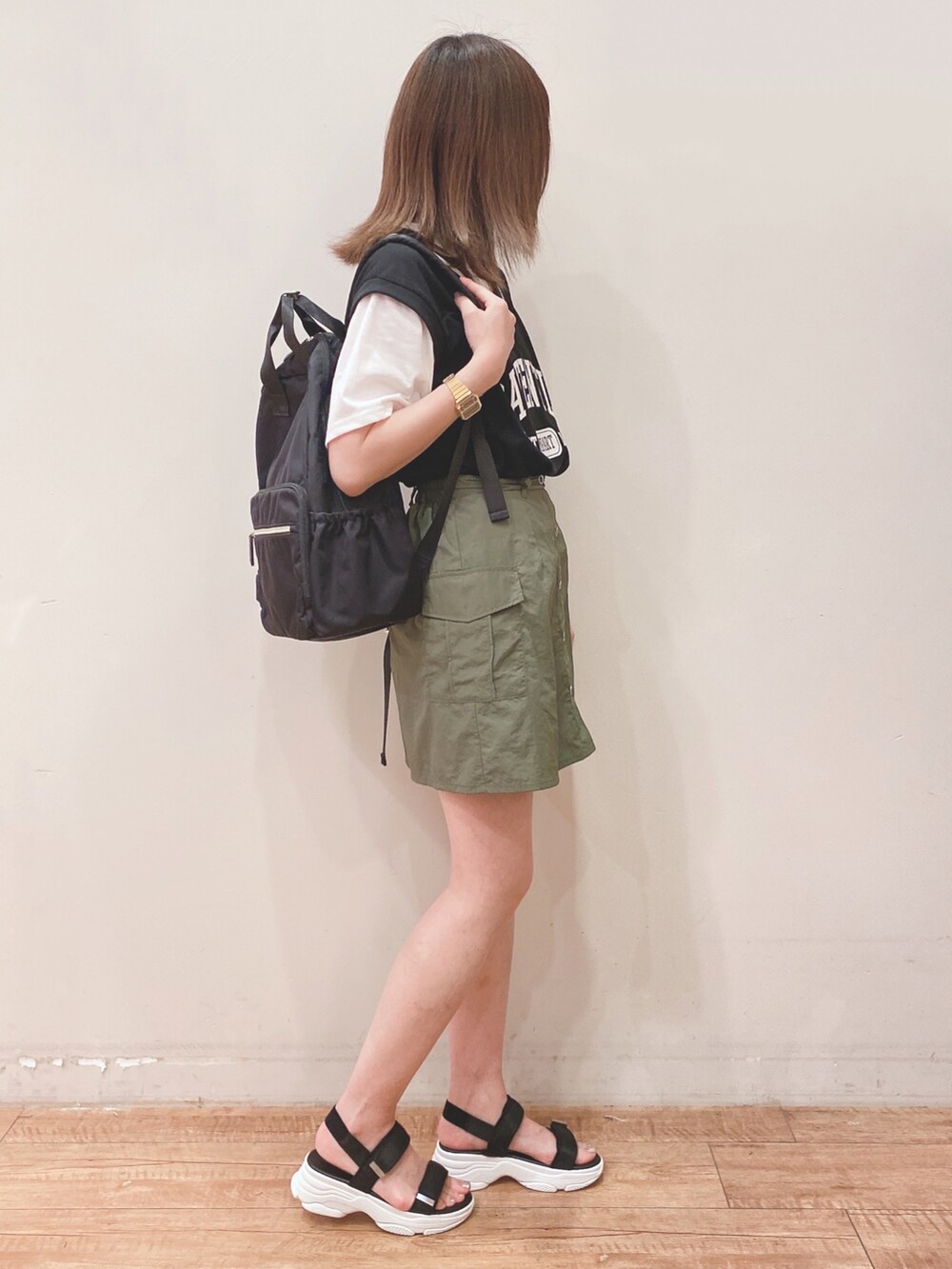 ブラック系のTシャツ/カットソー、グリーン系のスカート、ブラック系のサンダルを着用したレディースの夏コーディネートの2枚目の写真