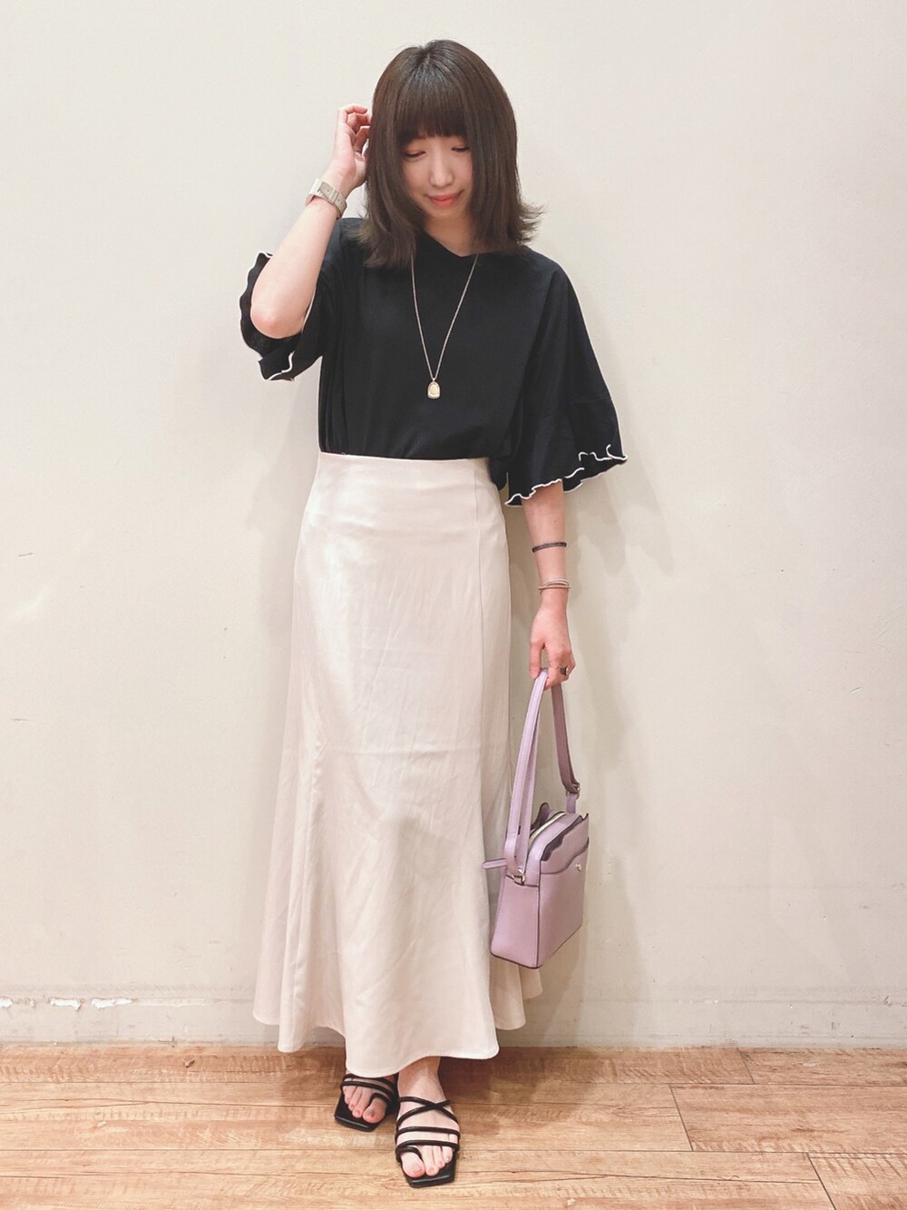 ブラック系のTシャツ/カットソー、ブラック系のサンダル、パープル系のショルダーバッグを着用したレディースの春コーディネートの4枚目の写真