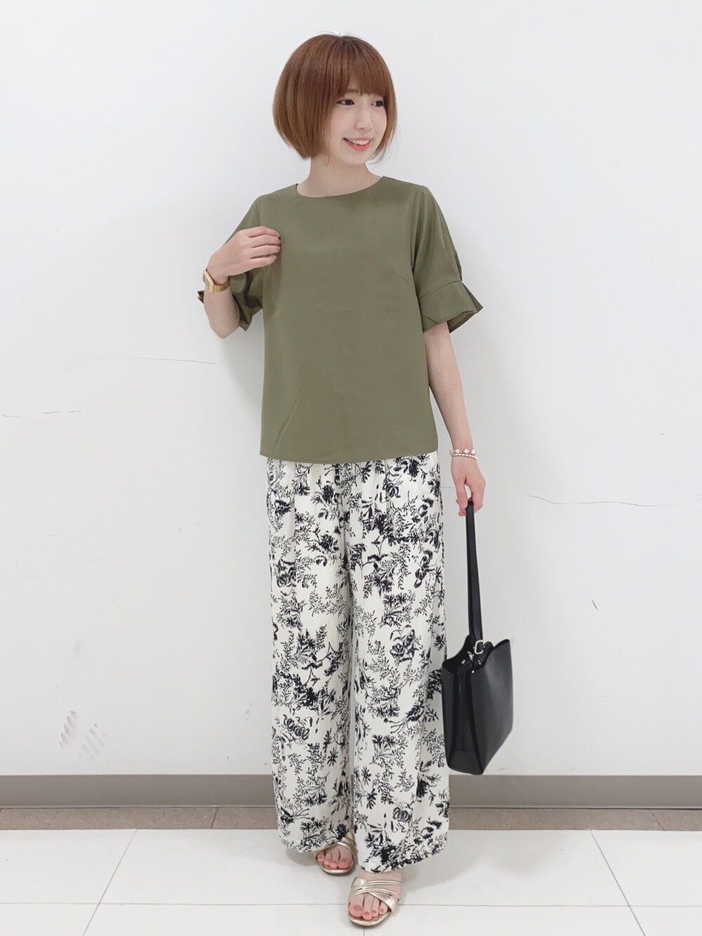 グリーン系のシャツ/ブラウス、ベージュ系のその他パンツ、ブラック系のショルダーバッグを着用したレディースの夏コーディネートの4枚目の写真