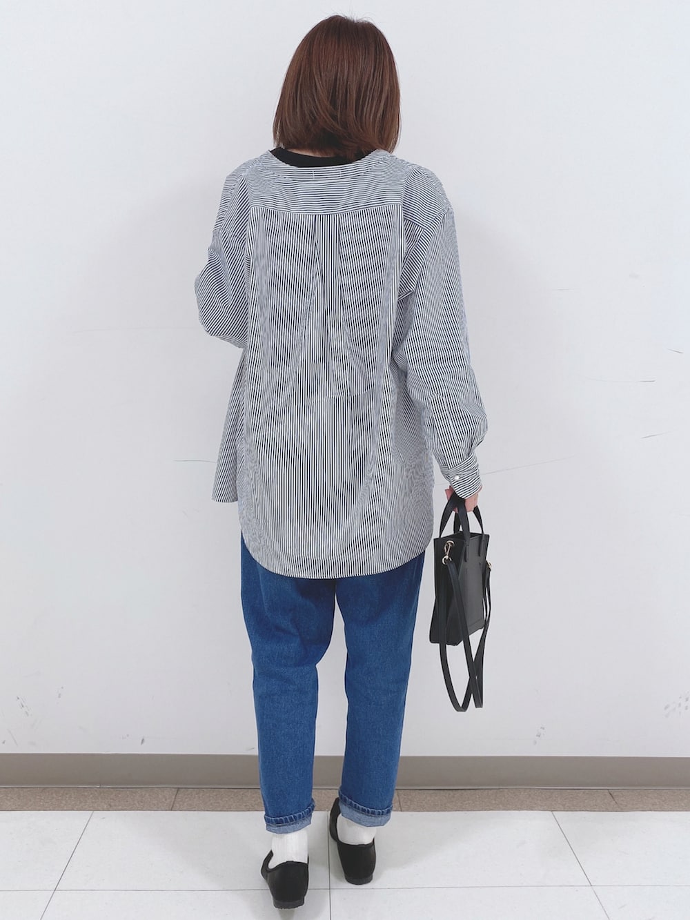 ブラック系のTシャツ/カットソー、ブルー系のシャツ/ブラウス、ブルー系のデニムパンツを着用したレディースの春コーディネートの3枚目の写真