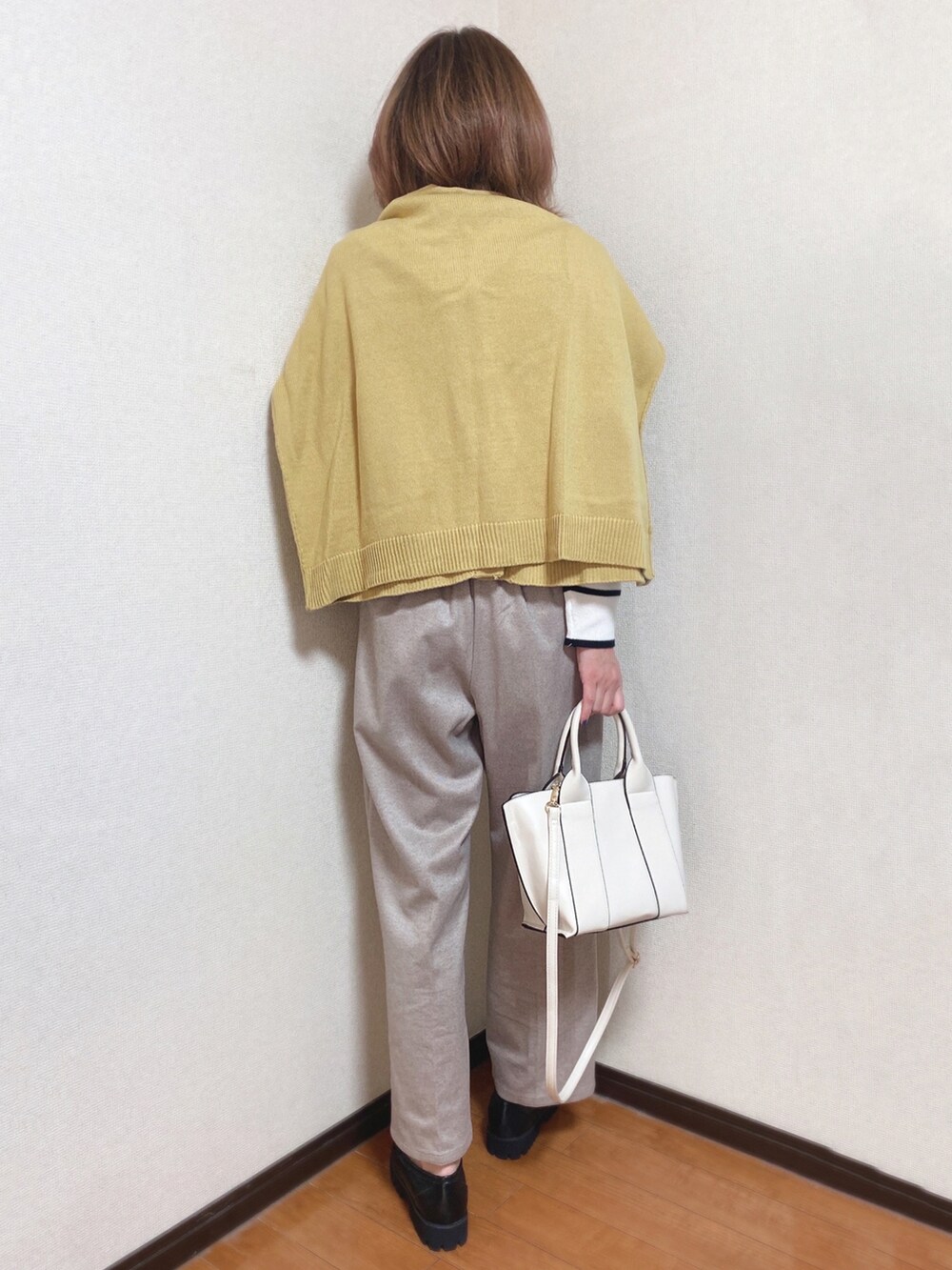 ブラック系のニット/セーター、イエロー系のカーディガン/ボレロ、ブラウン系のその他パンツを着用したレディースの冬コーディネートの2枚目の写真