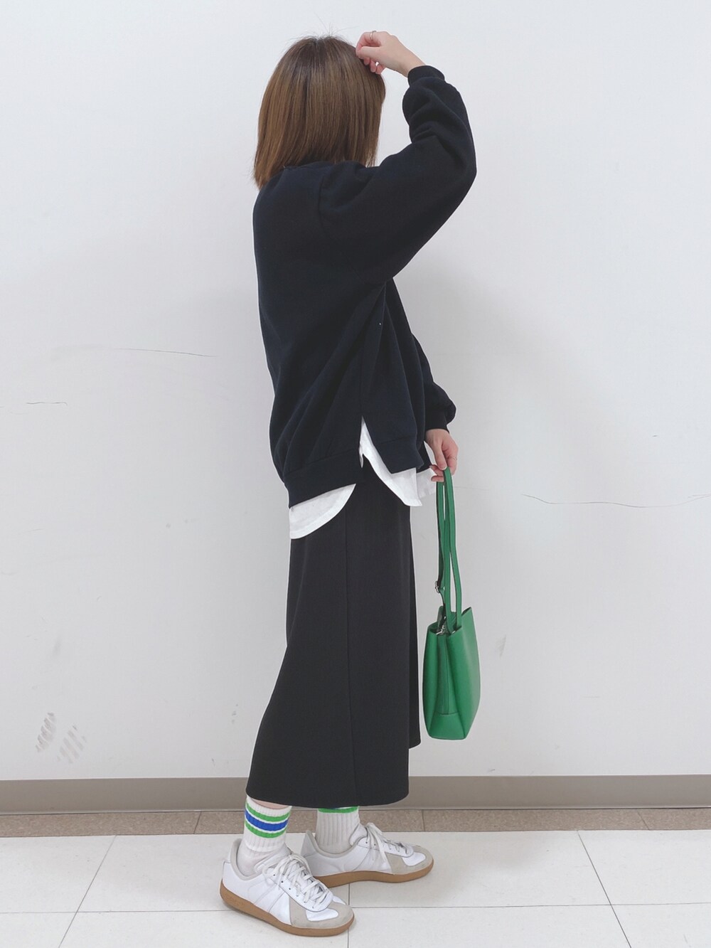 ブラック系のスウェット、ブラック系のスカート、ホワイト系のTシャツ/カットソーを着用したレディースの冬コーディネートの2枚目の写真