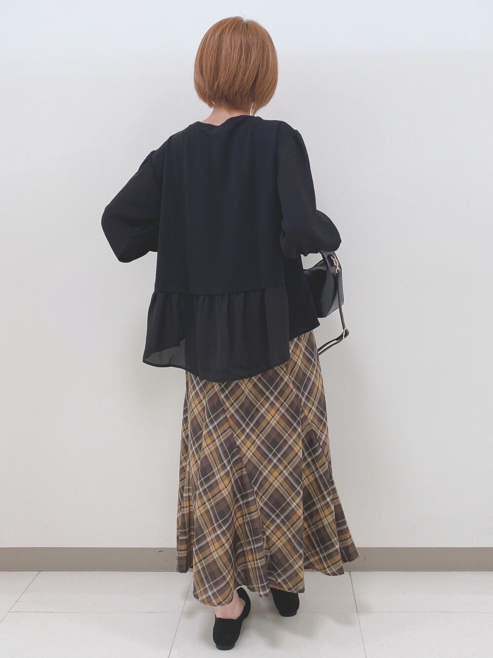 ブラック系のパンプス、ブラック系のトートバッグ、ブラック系のTシャツ/カットソーを着用したレディースの秋コーディネートの3枚目の写真