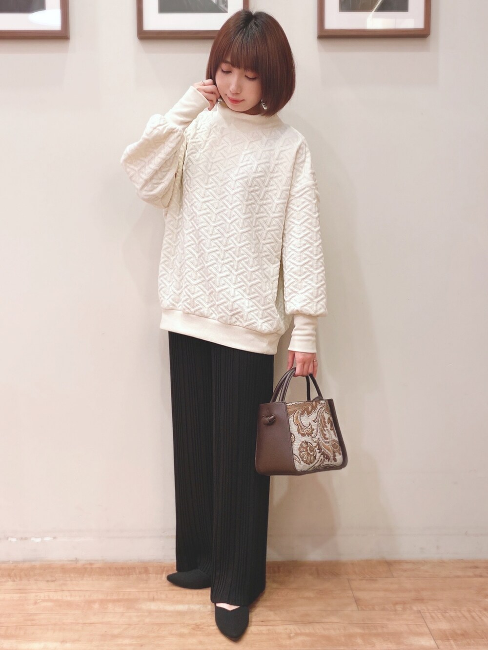 ホワイト系のスウェット、ブラウン系のトートバッグ、ブラック系のパンプスを着用したレディースの秋コーディネートの2枚目の写真