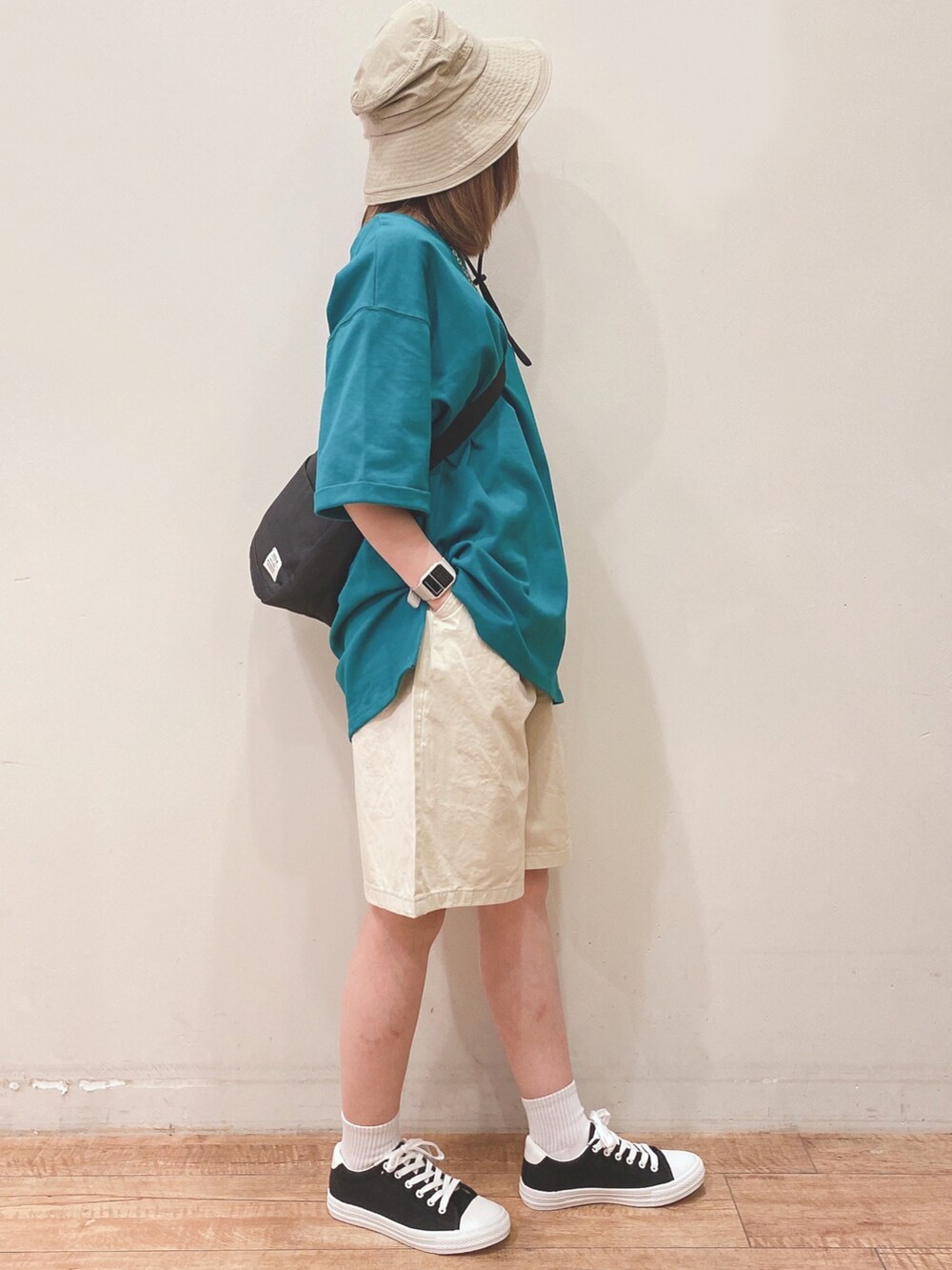 ブラック系のショルダーバッグ、グリーン系のTシャツ/カットソー、ベージュ系のその他パンツを着用したレディースの春コーディネートの2枚目の写真