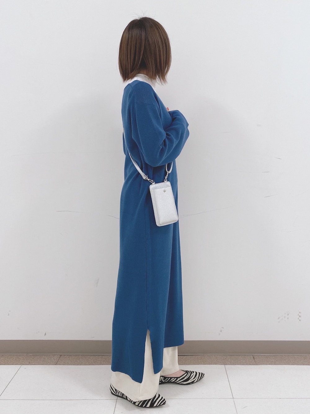 ホワイト系のTシャツ/カットソー、ブルー系のワンピース、ベージュ系のその他パンツを着用したレディースの冬コーディネートの2枚目の写真