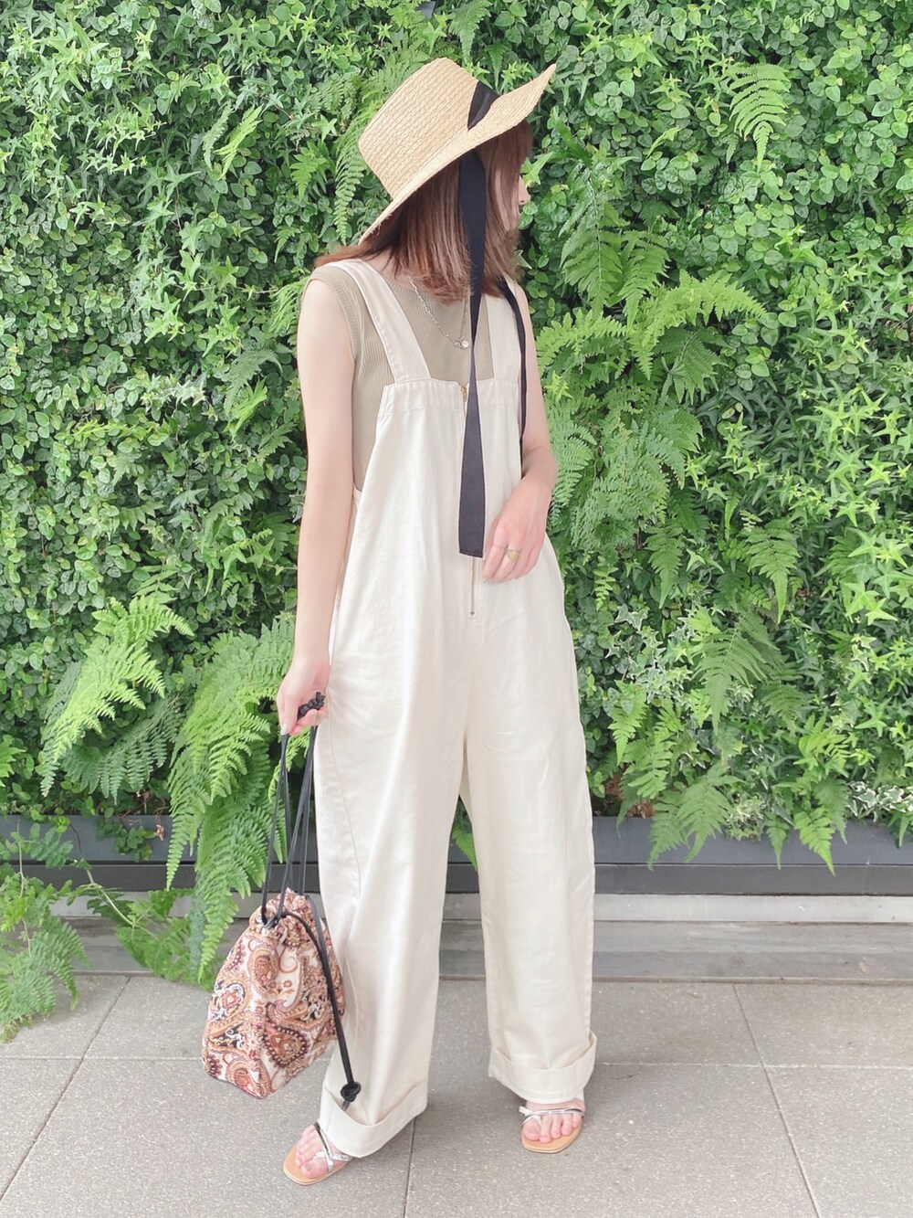 グリーン系のタンクトップ、ベージュ系のサンダル、ベージュ系のショルダーバッグを着用したレディースの夏コーディネートの2枚目の写真