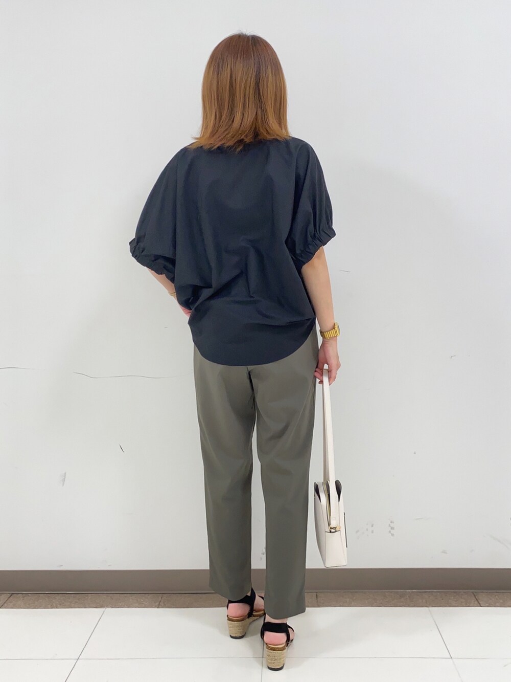 ブラック系のTシャツ/カットソー、グリーン系のその他パンツ、ホワイト系のショルダーバッグを着用したレディースの春コーディネートの3枚目の写真