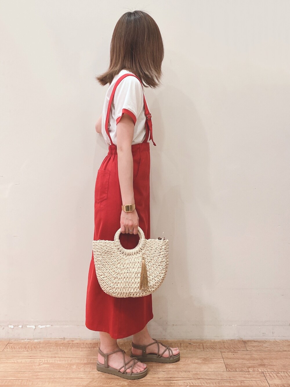レッド系のスカート、ホワイト系のショルダーバッグ、ベージュ系のサンダルを着用したレディースの夏コーディネートの2枚目の写真