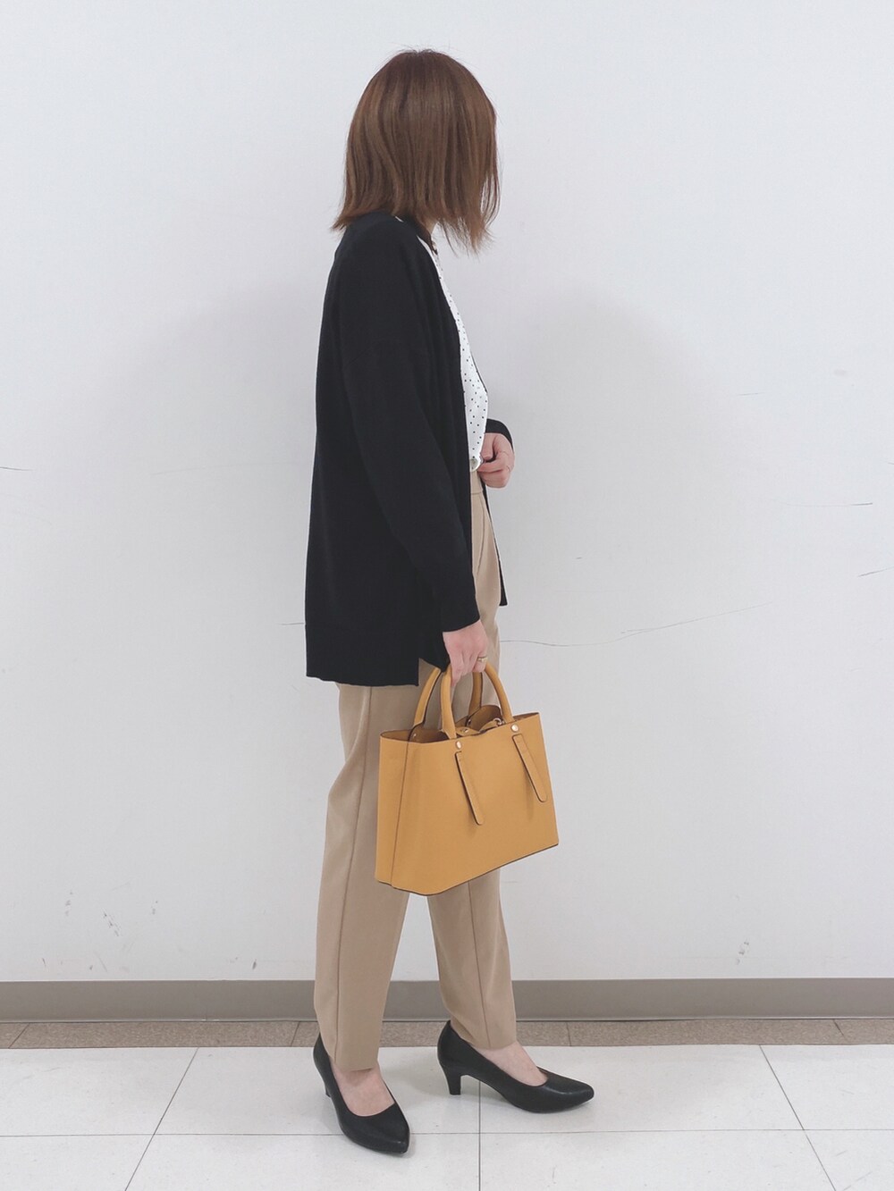 ホワイト系のシャツ/ブラウス、ブラック系のカーディガン/ボレロ、ベージュ系のその他パンツを着用したレディースの春コーディネートの2枚目の写真